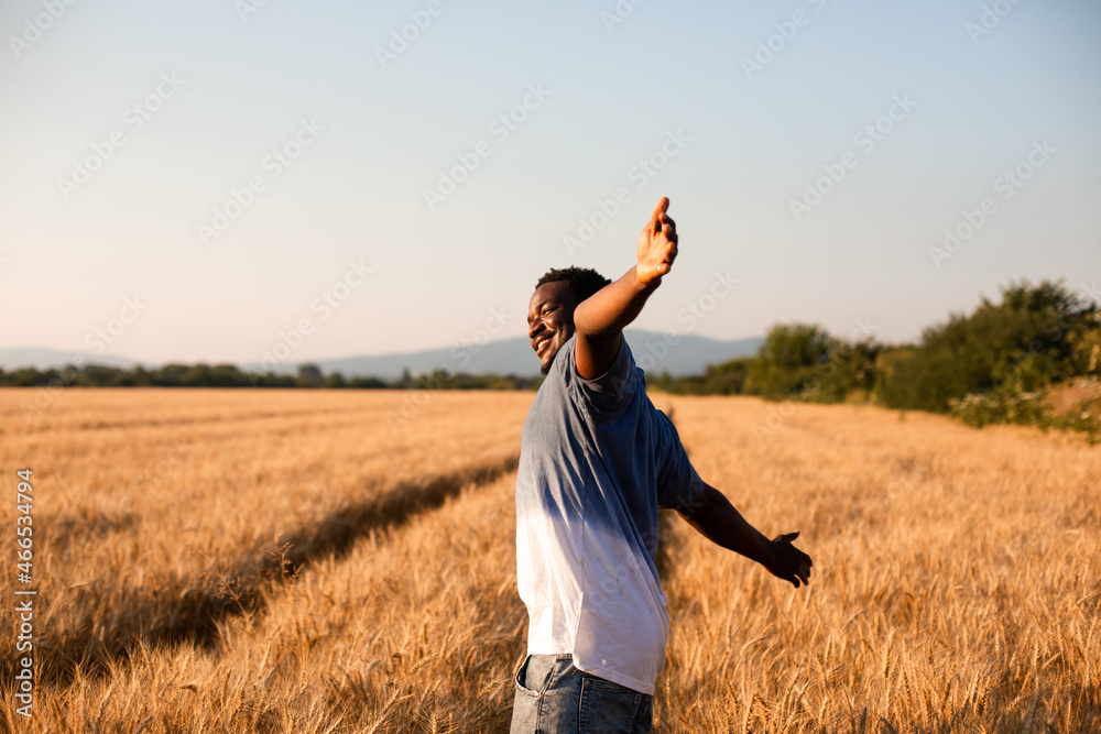 Young farmer standing in the middle of the field Young farmer standing in the middle of the field
