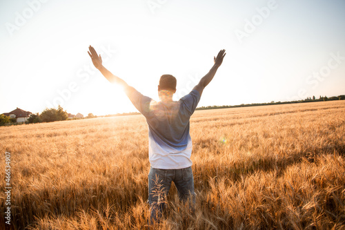 Unspecified man with hands up watching sunset