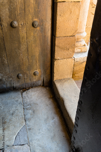 Open rustic wooden door at the entrance of a Romanesque church