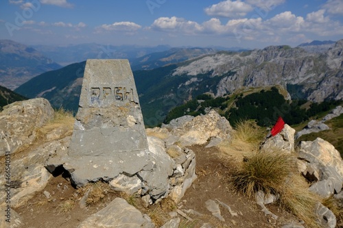 Mountain views during trekking along the most beautiful tourist loop on the Montenegrin side of Prokletije Mountains: Volusnica (1879 m) - Taljanka (2018 m) - Popadija (2057 m). Stone obelisk at top photo