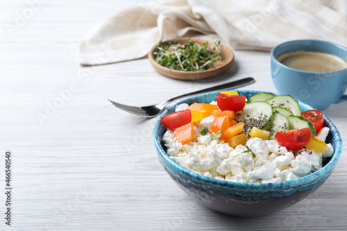 Delicious cottage cheese with vegetables and chia seeds served on white wooden table, space for text. Tasty breakfast