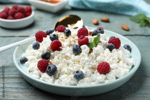 Delicious cottage cheese with fresh berries served for breakfast on light blue wooden table, closeup