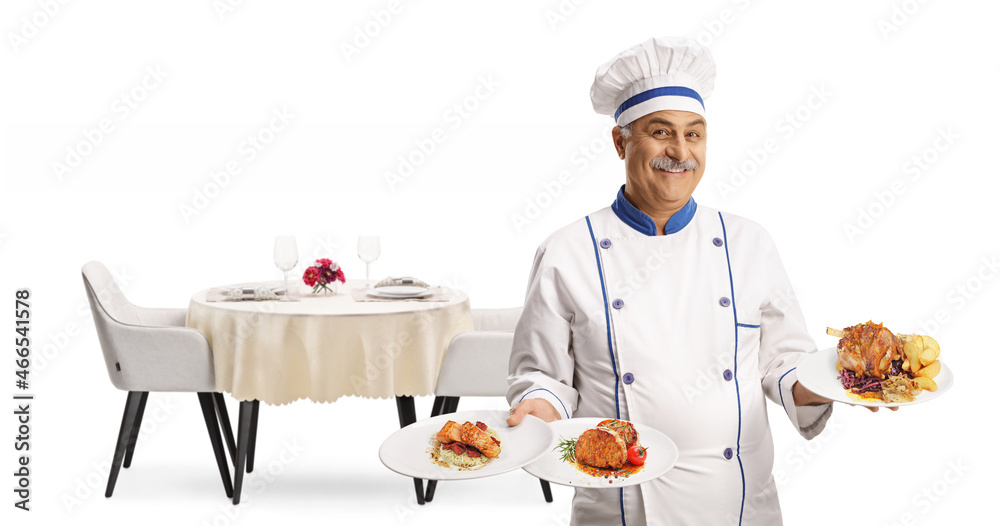 Male chef smiling and holding three plates with food in front of a restaurant table Male chef smiling and holding three plates with food in front of a restaurant table