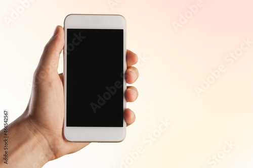 A hand holding a smartphone with a blank screen