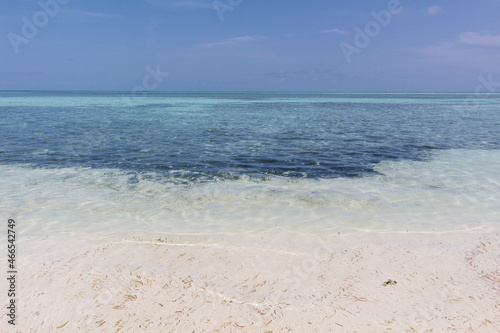 Playa paradisiaca soleada  agua cristalina y cielo azul