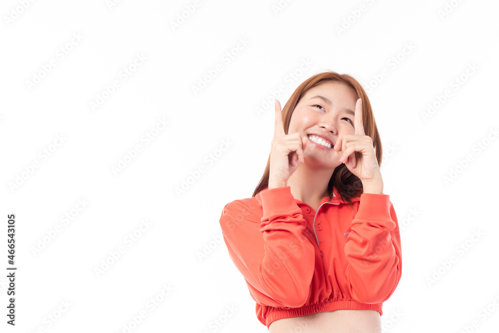 Beautiful Asian woman wearing casual clothes smile and pointing finger at copy space isolated on white background studio portrait. Beautiful Asian woman wearing casual clothes smile and pointing finger at copy space isolated on white background studio portrait.