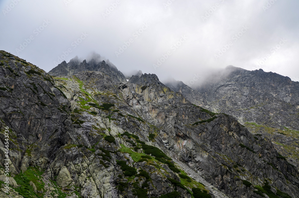 Amazing natural landscape with stones with rocks in fog and cloudy sky in the misty summer day. Mountain peaks in the Tatra Mountains, Slovakia