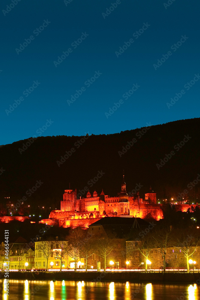 Cover page with stunning reddish night illumination over the old town, castle, river Neckar and main city bridge in Heidelberg, Germany, with copy space. Concept of historical architecture heritage.