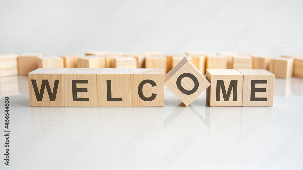 welcome text on a wooden blocks, gray background.