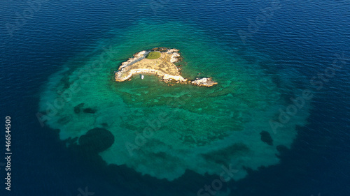 Aerial drone top down photo of small tropical exotic island covered in limestone with emerald sea
