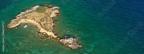 Aerial drone top down photo of small tropical exotic island covered in limestone with emerald sea