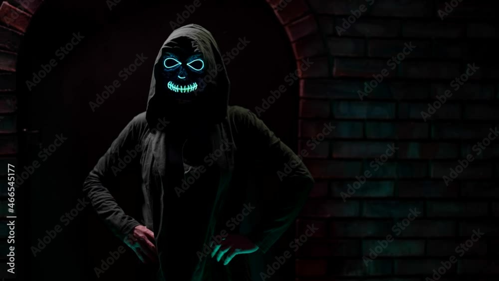 Halloween Mask Death in Neon Light Girl in flickering and frightening light. Mexican day of the dead for Halloween on a dark background. Halloween Mask Death in Neon Light Girl in flickering and frightening light. Mexican day of the dead for Halloween on a dark background.