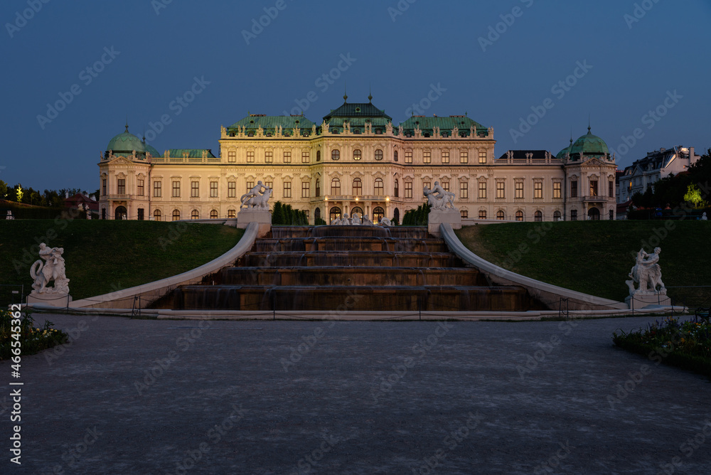Famous Belvedere castle (Schloss Belvedere) surrounded by gardens with fountains and classic statues at night, Vienna, Austria