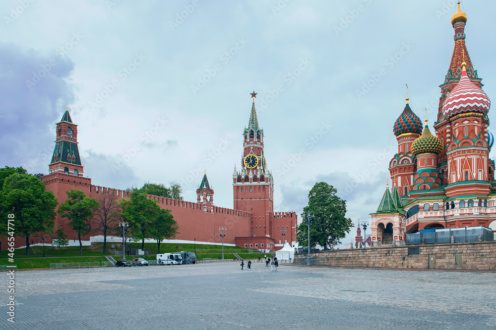 view from Red Square to the Kremlin Spasskaya Tower and St. Basil's Cathedral against the background of a cloudy sky. Moscow. Russia