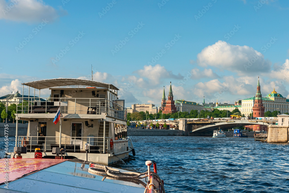 Obraz premium view from a tourist ship on the Moskva River and the towers of the Moscow Kremlin against the background of a blue cloudy sky