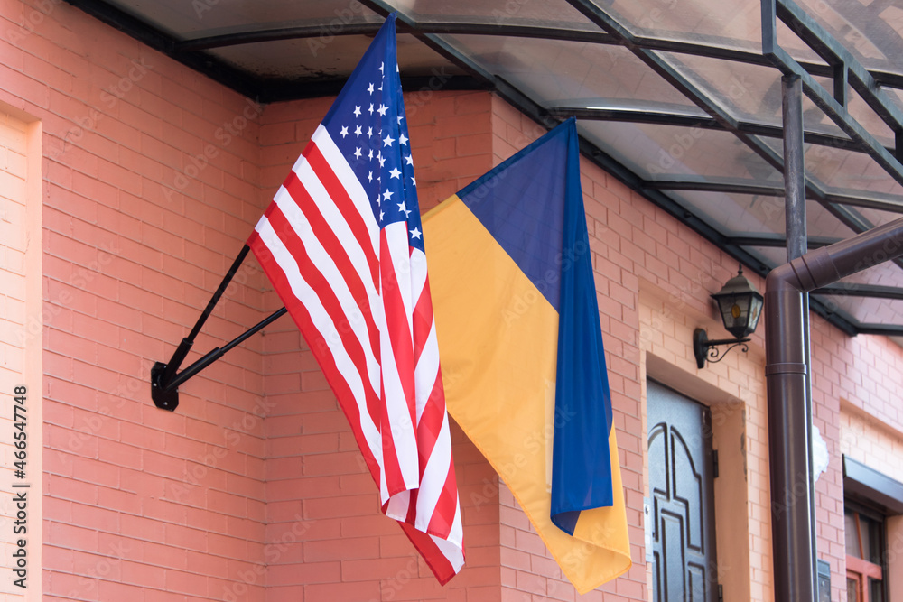 Flags of Ukraine and USA on building facade. American and ukrainian flags