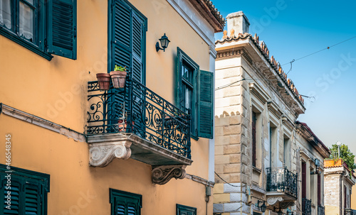 Fotografia, Obraz Colorful facades with ornate balconies and open and closed window shutters of traditional houses in the center of Athens, Greece