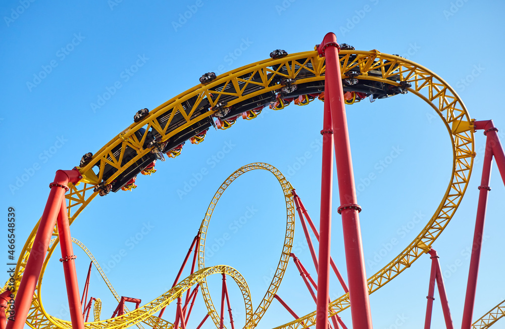 Roller coaster in an amusement park against the blue sky. The concept of attractions and extreme recreation Roller coaster in an amusement park against the blue sky. The concept of attractions and extreme recreation