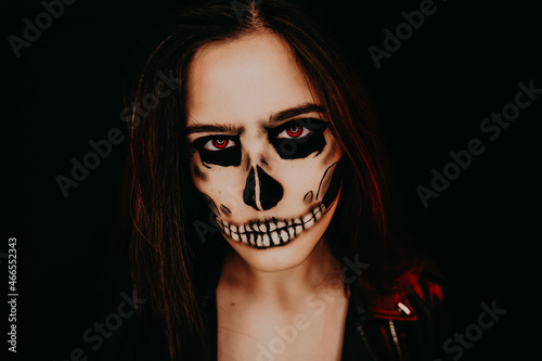 A girl with skull make up. Halloween happy party.