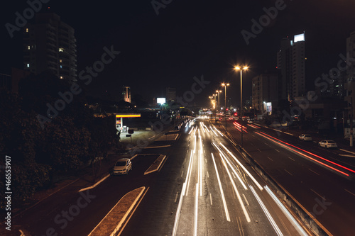 Car headlight trails on a city avenue at night