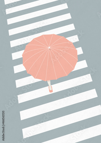 Woman comin 'down the street with an umbrella photo
