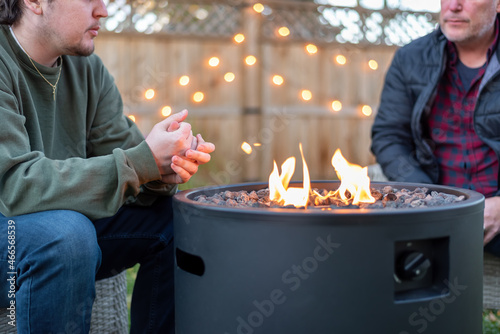 Wall Mural Father and son having a fireside chat in the backyard
