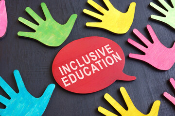 Inclusive education concept. Multi-colored palms on a dark surface and an inscription.