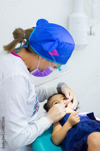 dentist looking at the teeth of a child lying down on a stretcher