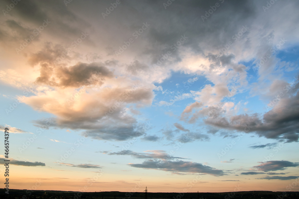 Bright landscape of dark clouds on yellow sunset sky in evening.