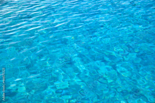 Closeup surface of blue clear water with small ripple waves in swimming pool.
