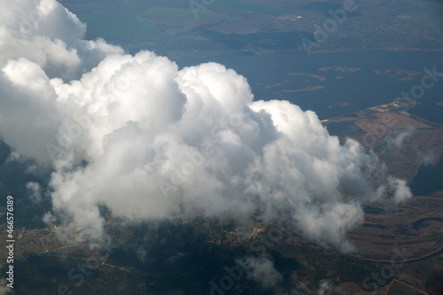 Aerial view from airplane window of white puffy clouds on bright sunny day