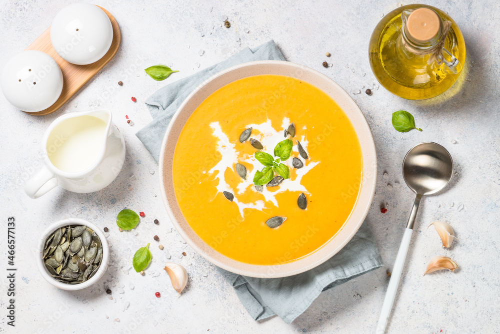 Pumpkin soup with cream. Top view image at white table. Pumpkin soup with cream. Top view image at white table.