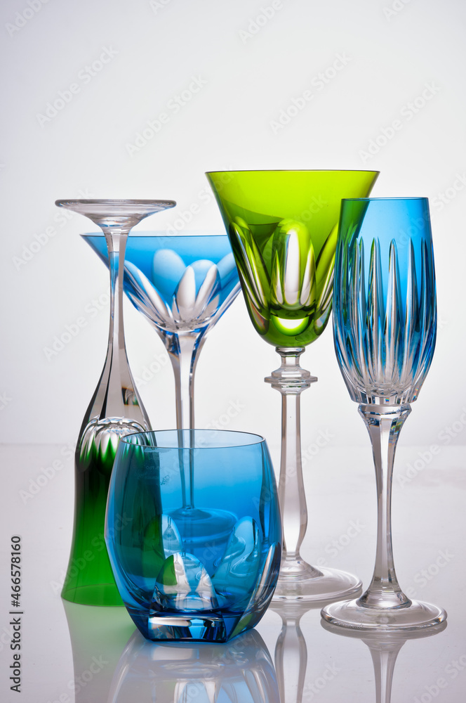 photographic arrangement of a set of different crystal glasses of different shapes, colors and uses photographic arrangement of a set of different crystal glasses of different shapes, colors and uses