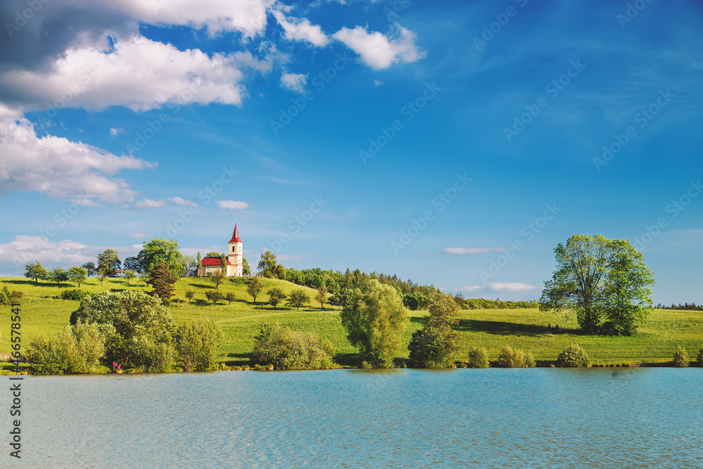 Church on the hill with lake in foreground. Bysicka church near SPA town Lazne Belohrad, Czech Republic.