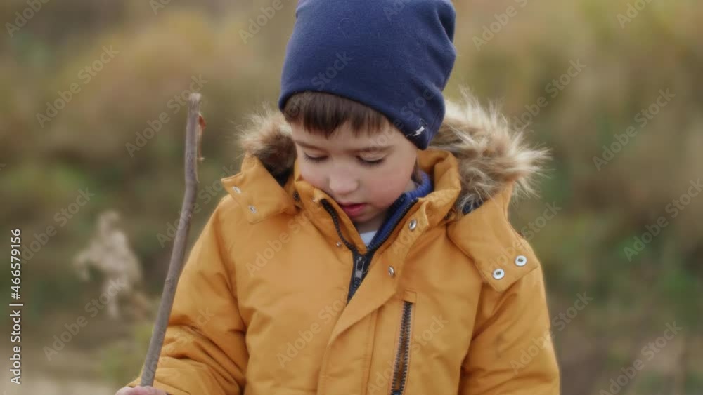 Boy at field with dried grass. Outdoor leisure activity for children in fall season. Kid's fashion for autumn days. Boy at field with dried grass. Outdoor leisure activity for children in fall season. Kid's fashion for autumn days.