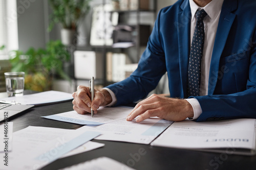 Cropped portrait of unrecognizable successful businessman signing contract at desk in office, copy space