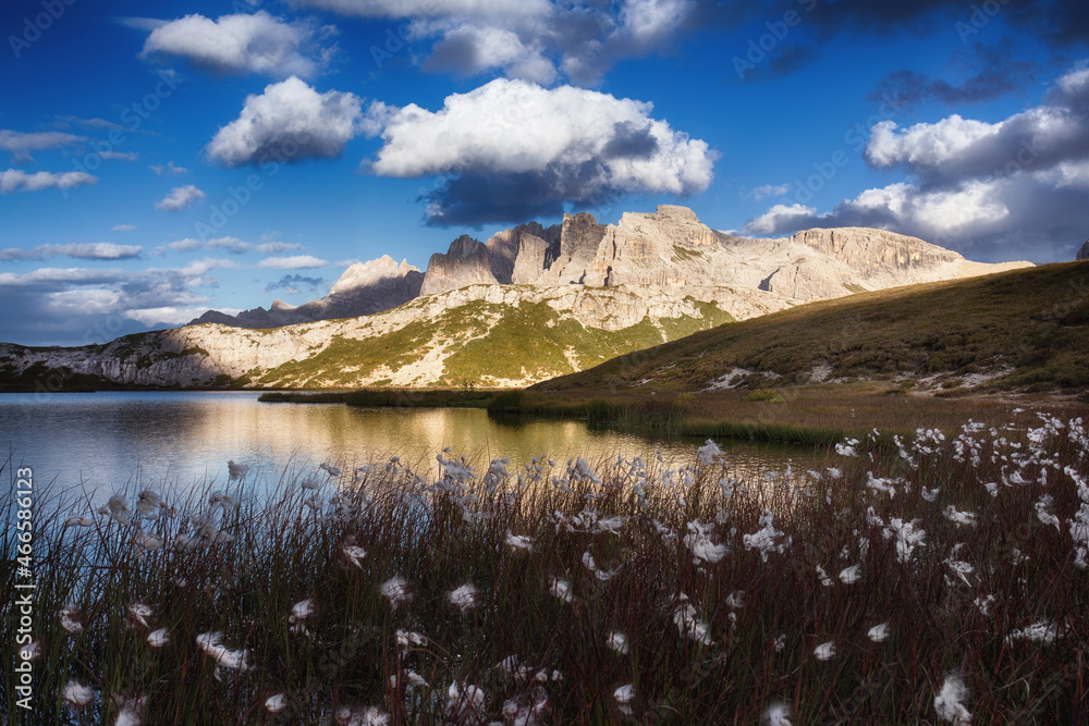 Evening landscape with a lake against a background of mountains in the Dolomites, South Tyrol, Italy. Lago di Piani in the Tre Cime Nature Park, postcard view. Autumn landscape with mountain flowers.