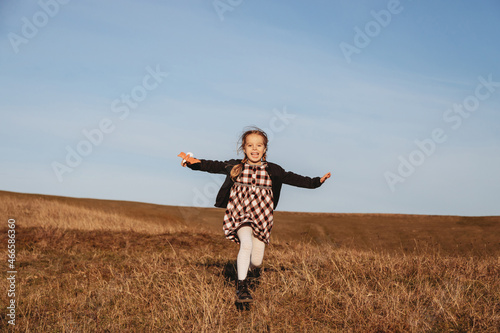 Little girl with toy running in the field