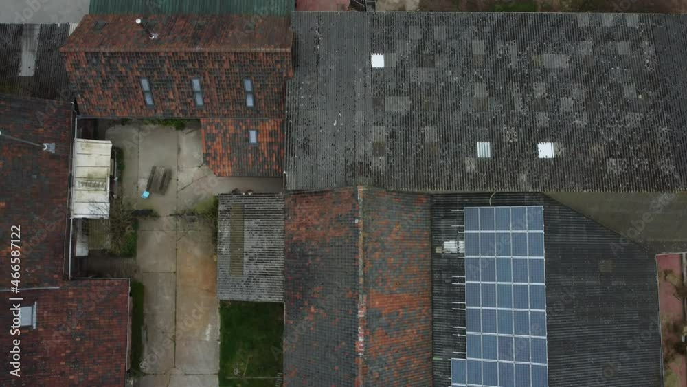 aerial drone top down shot over farm roof with solar panels on top aerial drone top down shot over farm roof with solar panels on top