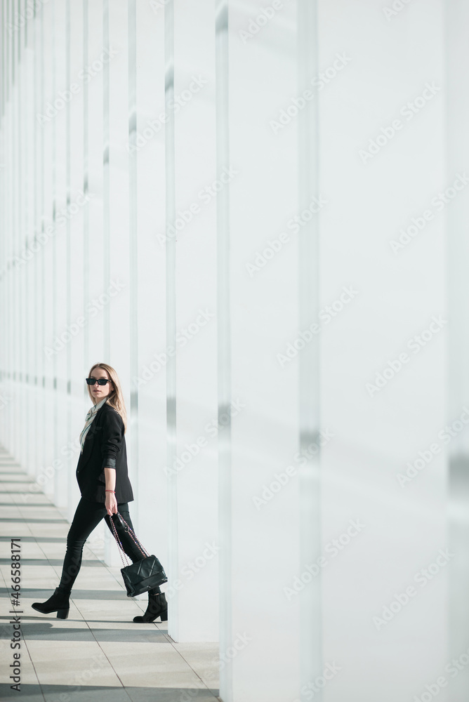 Beautiful young businesswoman walking outside corporate building Beautiful young businesswoman walking outside corporate building