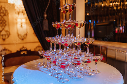 tower of champagne glasses with a cherry. banquet in a restaurant, birthday celebration.
