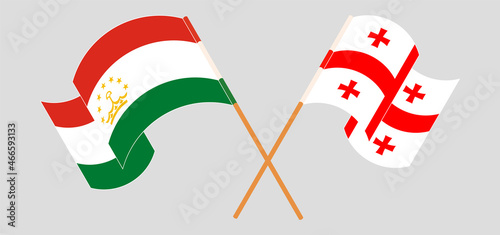 Crossed and waving flags of Tajikistan and Georgia
