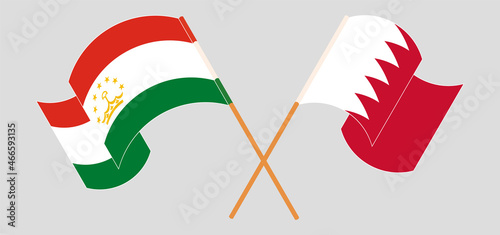 Crossed and waving flags of Tajikistan and Bahrain
