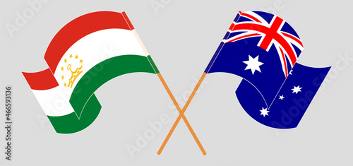 Crossed and waving flags of Tajikistan and Australia
