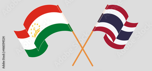 Crossed and waving flags of Tajikistan and Thailand