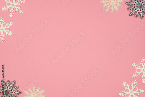 Christmas concept. Frame made of white and gray snowflakes on a pastel pink background. top view  copy space