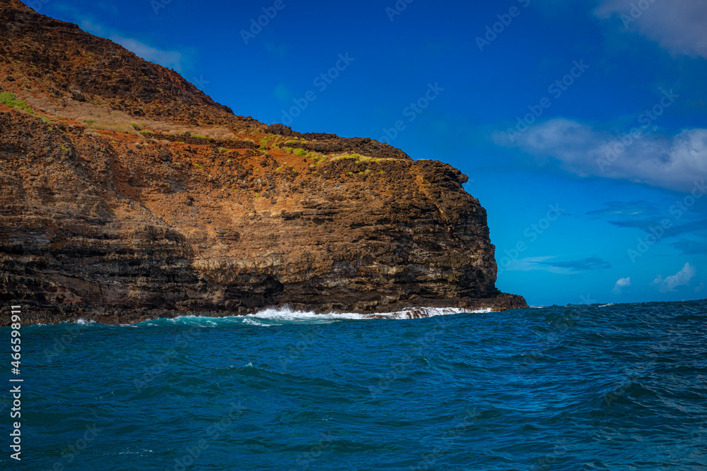 2021-11-01 ROCKY SHORE AND CLIFFS ALONG THE NA PALI COAST ON KAUAI HAWAII WITH A BRIGHT BLUE SKY