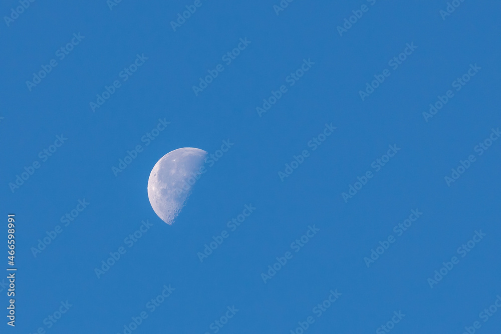 Natural phenomenon, Half moon in daytime with blue clear sky, A completely normal occurrence in astronomy is that the moon is directly opposite the sun in the sky, Nature background. Natural phenomenon, Half moon in daytime with blue clear sky, A completely normal occurrence in astronomy is that the moon is directly opposite the sun in the sky, Nature background.