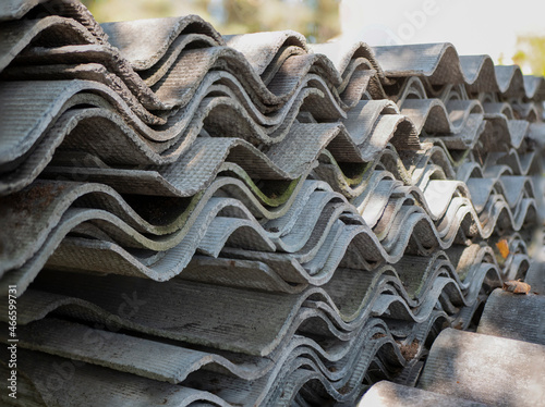 Stacked sheets of slate. Corrugated asbestos-cement sheets. Health-threatening roofing materials