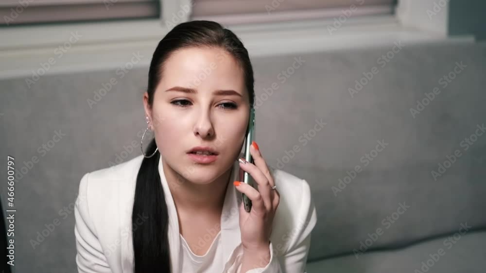 portrait of happy, surprised, excited brunette business woman talking by phone in gray office. gain, good phone call. success, victory, present. slow motion.